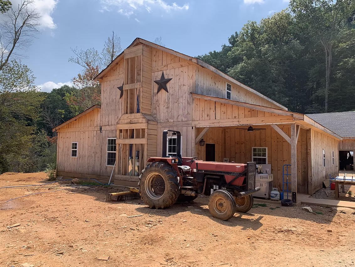 Timber frame barn aisle with finished wood walls and stalls