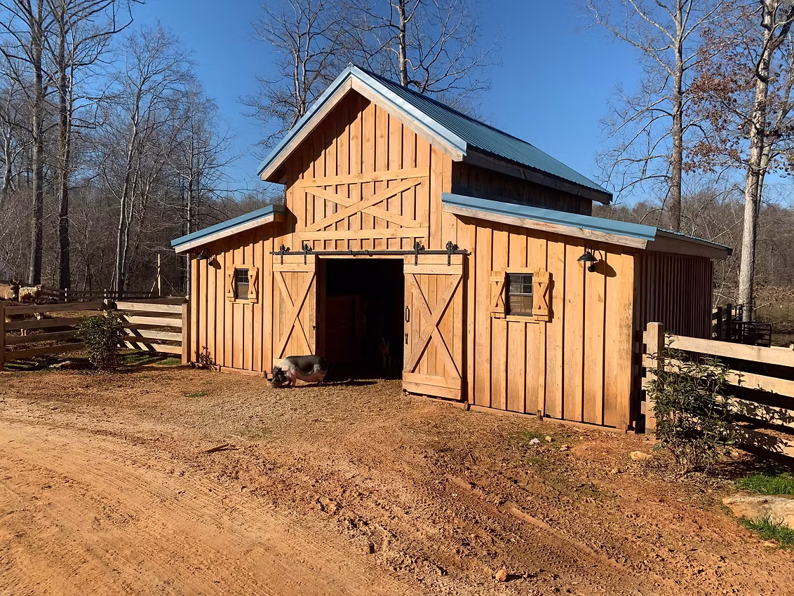 Timber frame barn interior with exposed beams and finished stalls