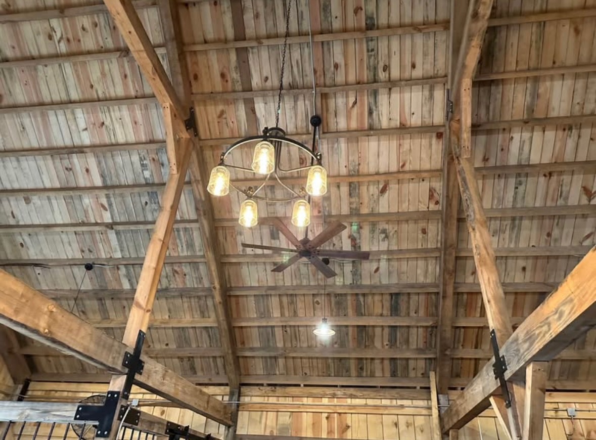 Timber frame ceiling with exposed trusses and a chandelier